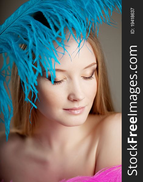 The image of a beautiful girl with colorful feathers