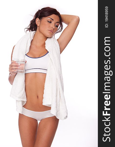 Fitness woman on white background drinking water after workout
