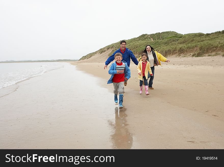 Happy family on beach running