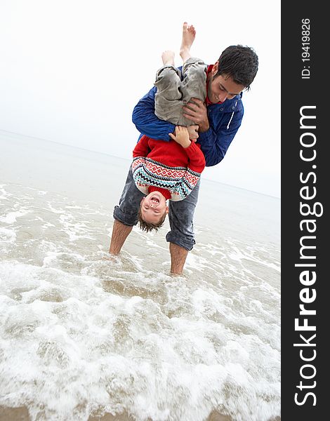 Happy father with son on beach having fun