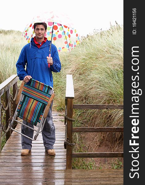 Young man with umbrella smiling