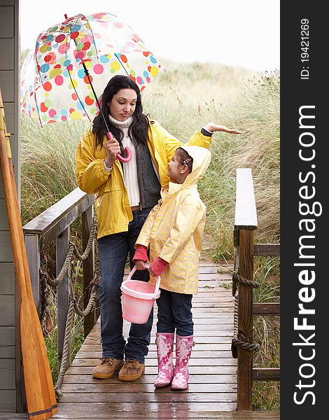 Mother and daughter with umbrella looking sad