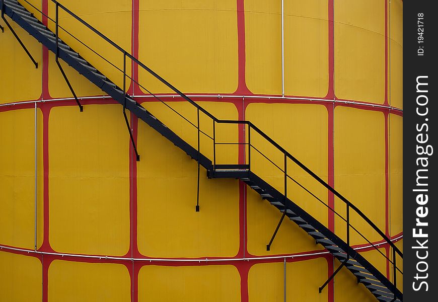 Closeup of yellow cistern whit black metal steps