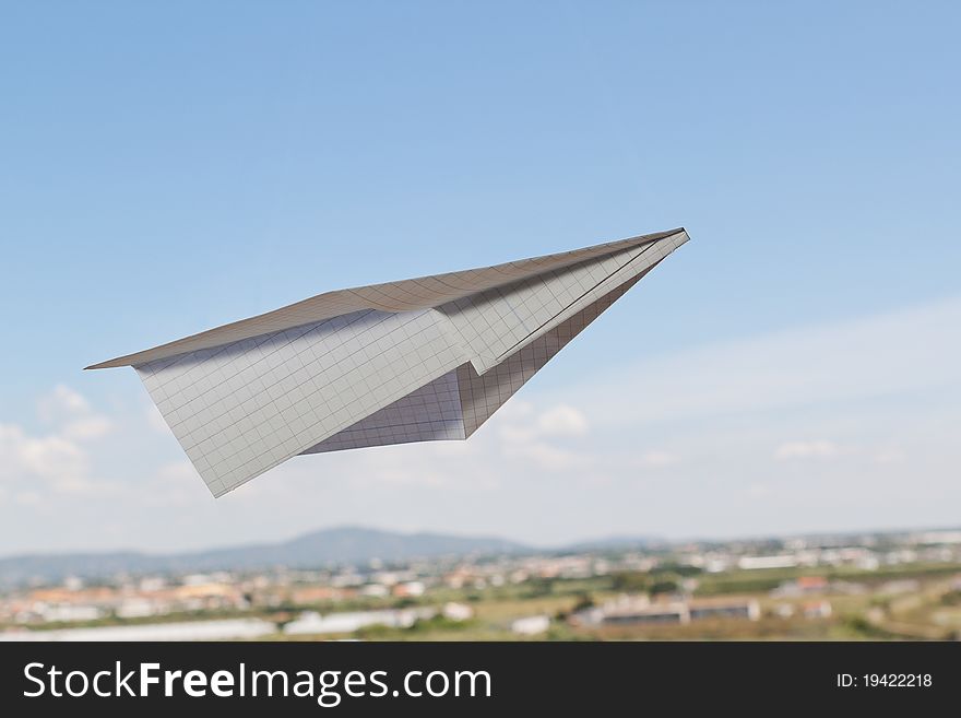 Paper airplane against the blue sky with a beautiful horizon