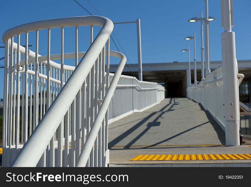 White Handrail along a trainstation platform. White Handrail along a trainstation platform