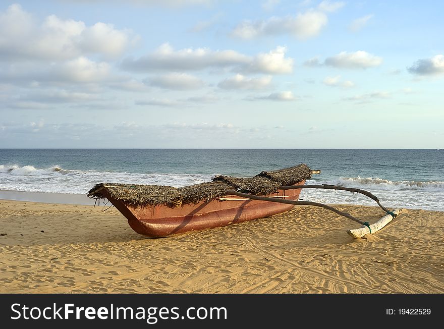 Traditional sri lankan fishing boat on ocean beach at sunset