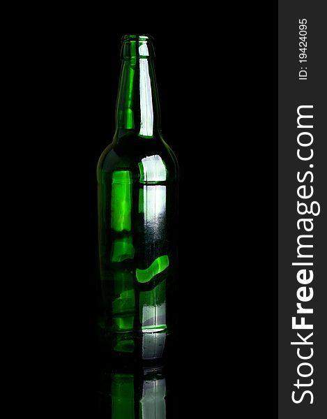 Green glass bottle isolated on a black background