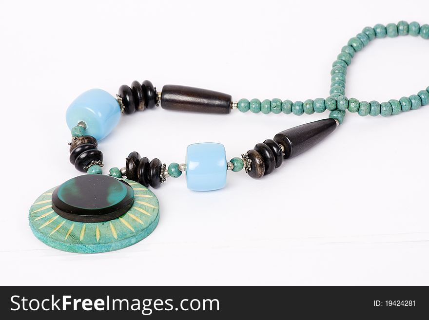 A woman's necklace made of pure stones and minerals of olive green, seafoam green, and Wood on an isolated white background. A woman's necklace made of pure stones and minerals of olive green, seafoam green, and Wood on an isolated white background