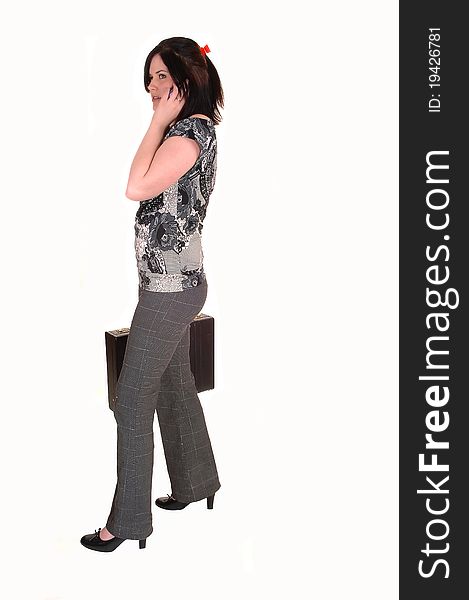 A young business woman with a briefcase ans a cell phone in her
hand, in slakes and blouse, for white background. A young business woman with a briefcase ans a cell phone in her
hand, in slakes and blouse, for white background.