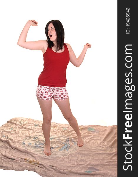 A lovely young woman is stretching after a good night sleep, standing
on her comforter in night wear shorts, for white background. A lovely young woman is stretching after a good night sleep, standing
on her comforter in night wear shorts, for white background.