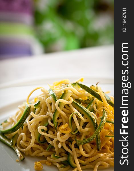 Tagliolini, a type of fresh pasta similar to spaghetti, in a courgettes and lemon sauce, portrait. Tagliolini, a type of fresh pasta similar to spaghetti, in a courgettes and lemon sauce, portrait.