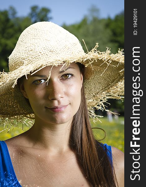 Beautiful young girl in the park with straw hat