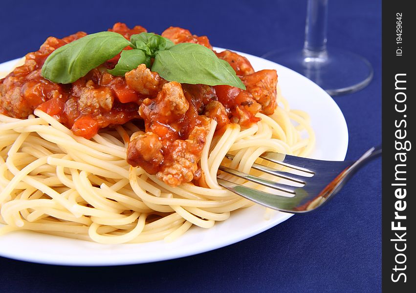 Spaghetti bolognese on a plate being eaten with a fork