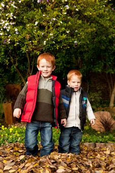 Two Happy, Smiling Brothers Standing In A Pile Of Stock Image Two Happy, Smiling Brothers Standing In A Pile Of Stock Image