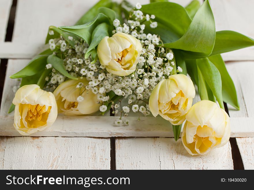 Bouquet of white tulips on white wooden table