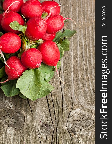 Top view on bunch of fresh radishes on old wooden table