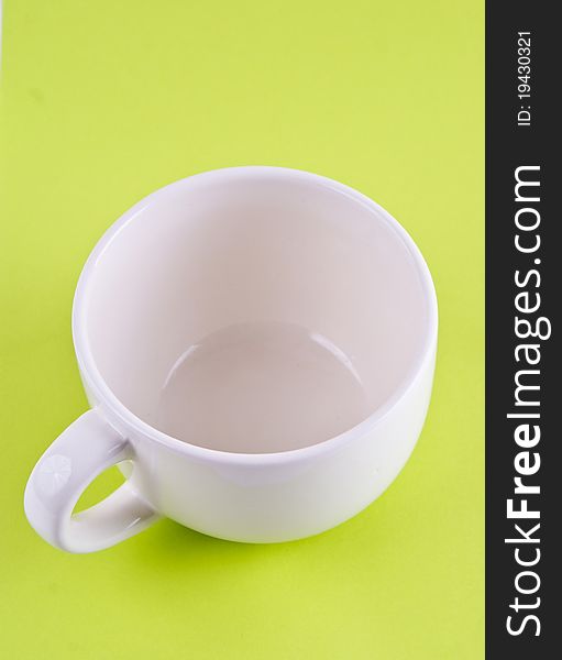 White empty cup. On a green background