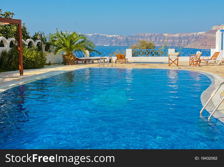 Magic blue swimming pool on island of Santorini, Fira in Greece. Caldera view on a background. Magic blue swimming pool on island of Santorini, Fira in Greece. Caldera view on a background.