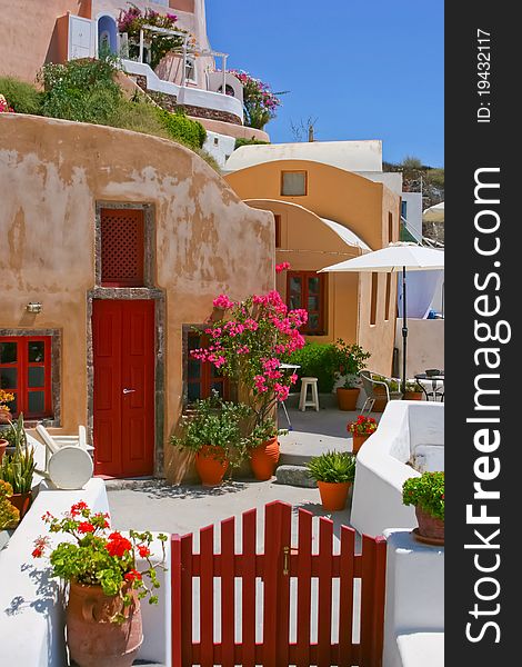 Colorful quiet backyard with beautiful flowers and classic traditional architecture in Santorini, Fira, Greece. Colorful quiet backyard with beautiful flowers and classic traditional architecture in Santorini, Fira, Greece