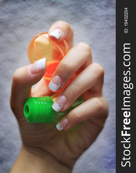 French manicure for beautiful, healthy hands. Accessories are the orange and green playing lamps. French manicure for beautiful, healthy hands. Accessories are the orange and green playing lamps