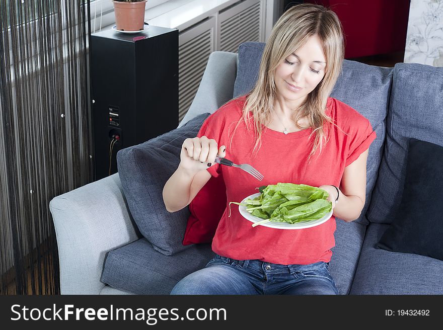 Beautiful blond woman eating green leaves as a healthy meal. Beautiful blond woman eating green leaves as a healthy meal