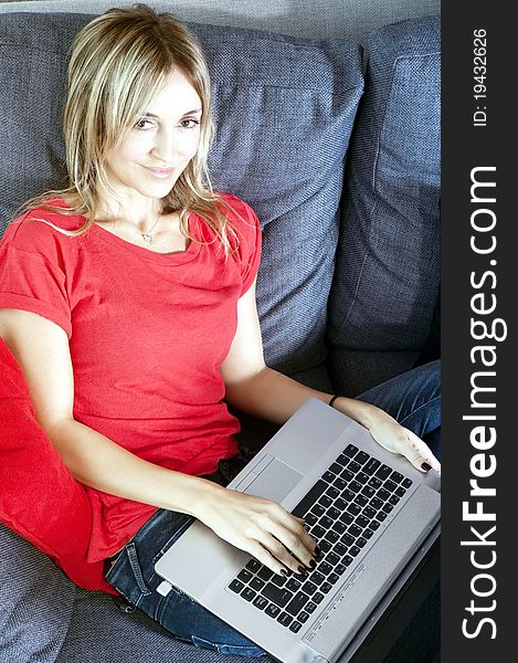 Happy working woman sitting on her couch with her laptop. Happy working woman sitting on her couch with her laptop