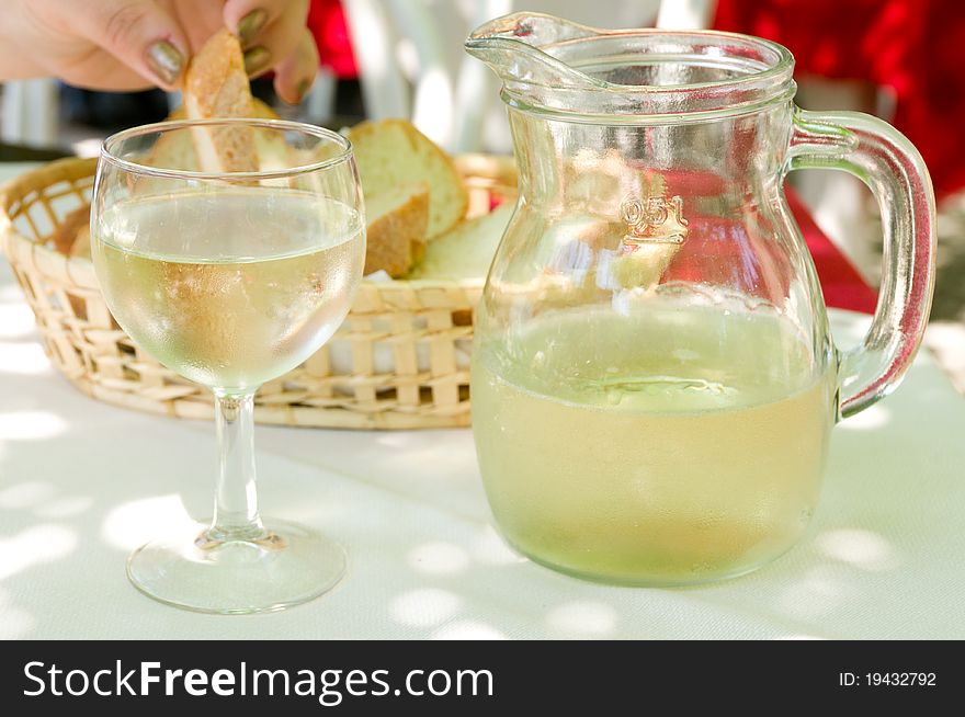 White wine in a glass and a bowl, bread on background. White wine in a glass and a bowl, bread on background