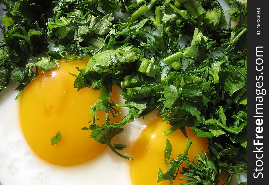 Fried eggs with greenery on a frying pan. Fried eggs with greenery on a frying pan.