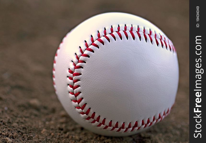 Closeup of a Baseball Sitting in Infield Dirt