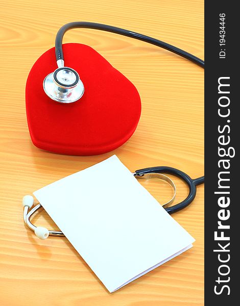 Paper note,stethoscope and red heart on wood background. Paper note,stethoscope and red heart on wood background