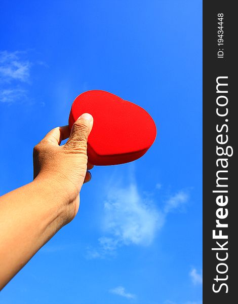 Red heart in hand with blue sky. Red heart in hand with blue sky