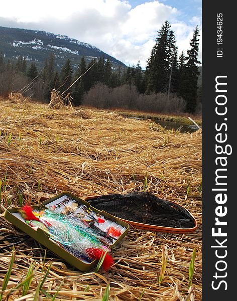 A landing net and fully stocked fly box on a stillwater lake in Whistler, British Columbia, Canada. A landing net and fully stocked fly box on a stillwater lake in Whistler, British Columbia, Canada.