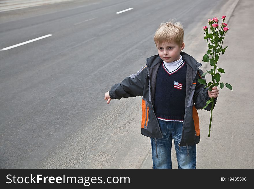 A boy with flowers stops the car