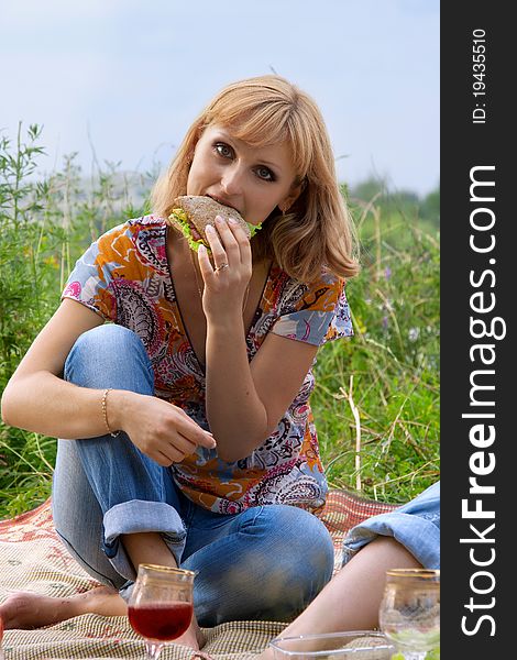 Young girl eating a sandwich at a picnic
