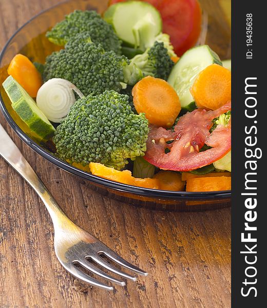 Mixture of vegetables in the plate on the wooden background