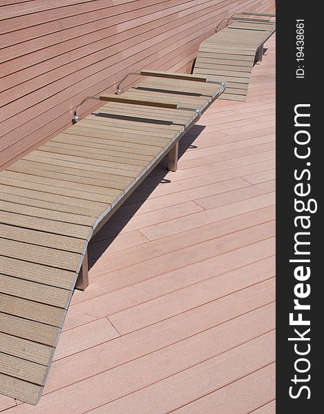 A wooden bench along boardwalk during a hot sunny day. A wooden bench along boardwalk during a hot sunny day