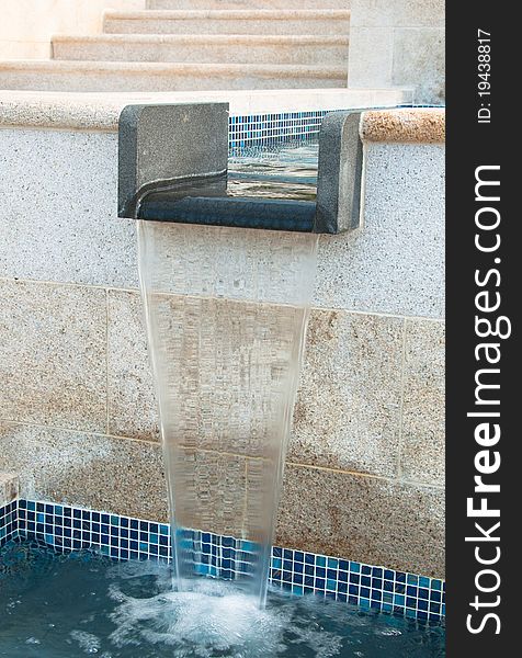 A portrait of water fountain with steps on the background