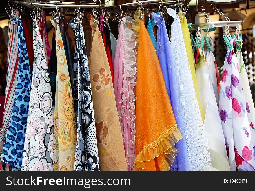 Various colorful scarfs on clothes-pegs sale at street outdoors