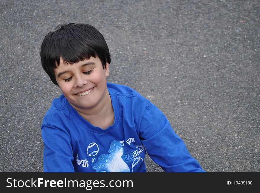 An adorable little boy has his eyes closed and he smiles happily, dreaming with his wonderful childhood. An adorable little boy has his eyes closed and he smiles happily, dreaming with his wonderful childhood.