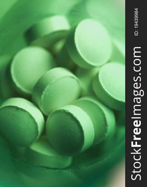 Macro view of pills shot in a green medicine bottle