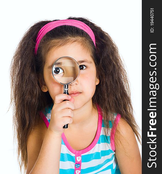 Little girl looking through a magnifier