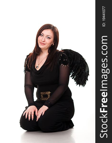 Beautiful woman in black wings sitting pensive isolated on white