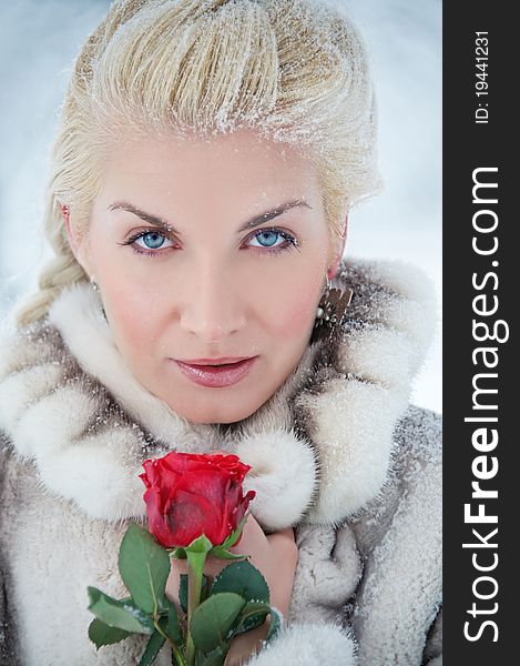 Attractive blond woman with a red rose