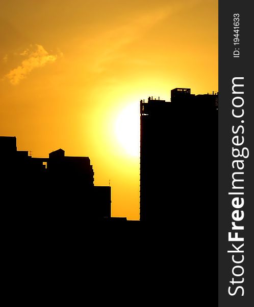 Blazing summer sun setting, creating silhouette of buildings. Blazing summer sun setting, creating silhouette of buildings.