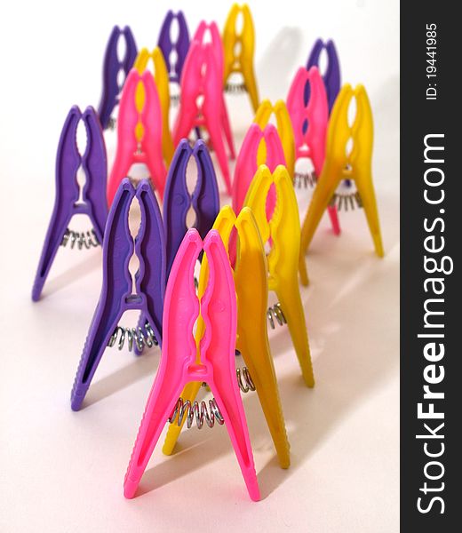 Bright clothes pegs standing on white background as a crowd