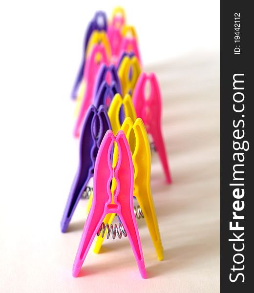 Bright clothes pegs standing in line