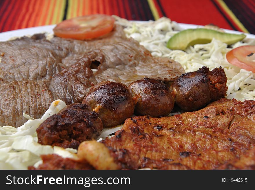 Closeup of plate of grilled beef and sausage