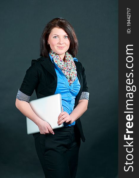 The businesswoman at the office with the computer in hands