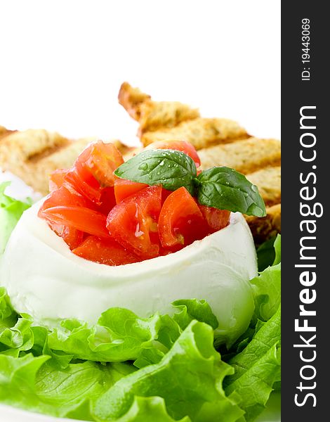 Stuffed buffalo mozzarella with tomatoes and basil on lettuce over white isolated background. Stuffed buffalo mozzarella with tomatoes and basil on lettuce over white isolated background