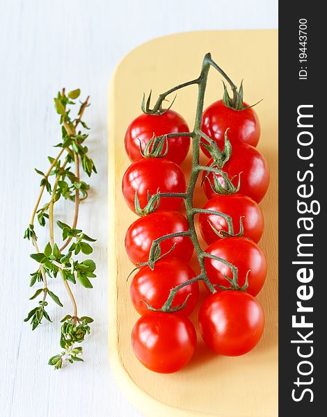 Fresh garden tomatoes  and thyme on a white board. Fresh garden tomatoes  and thyme on a white board.